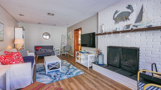 living room featuring a fireplace, a textured ceiling, and dark hardwood / wood-style floors