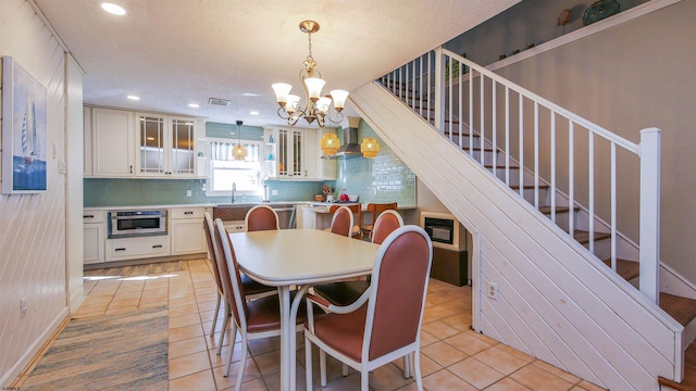 tiled dining area with sink and an inviting chandelier