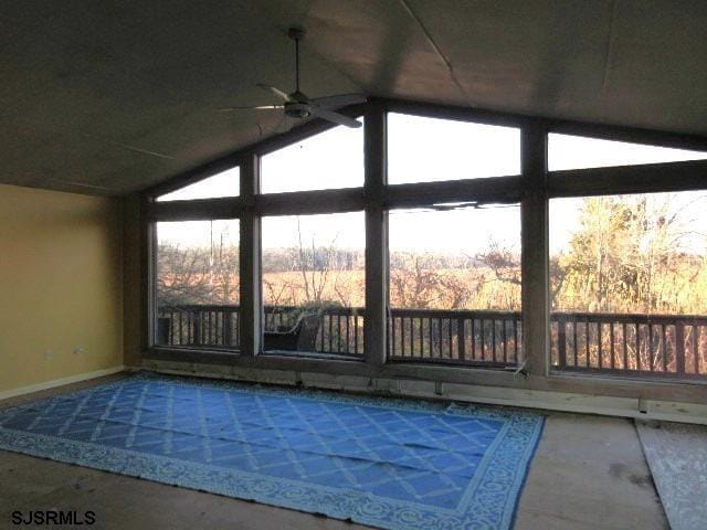 interior space with lofted ceiling, ceiling fan, and a wealth of natural light