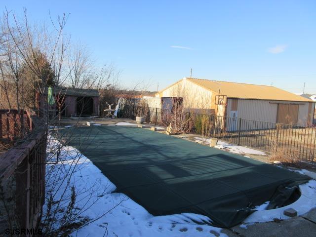 snow covered pool featuring a patio area