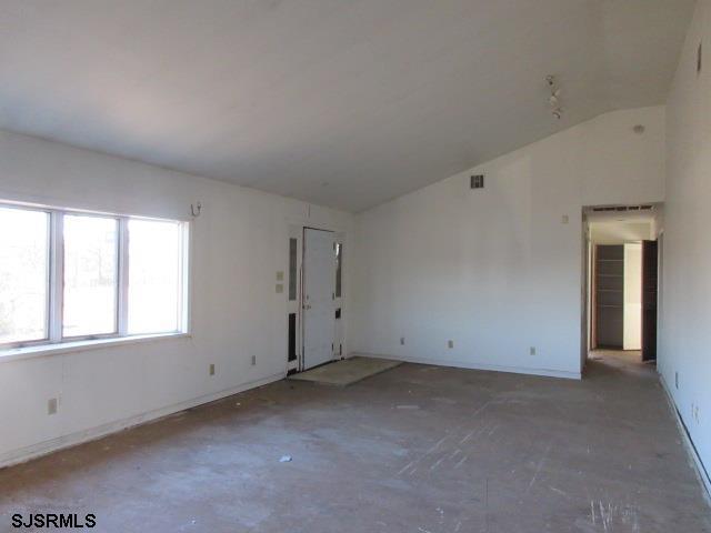 empty room featuring lofted ceiling