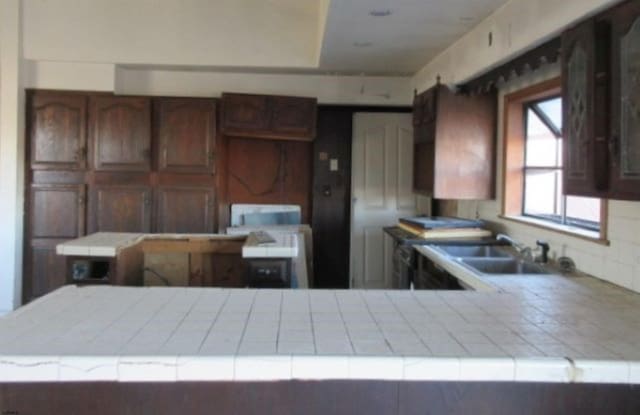 kitchen featuring sink, tile countertops, and kitchen peninsula