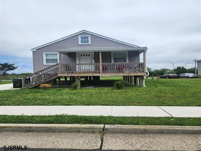 view of front facade featuring covered porch and a front lawn