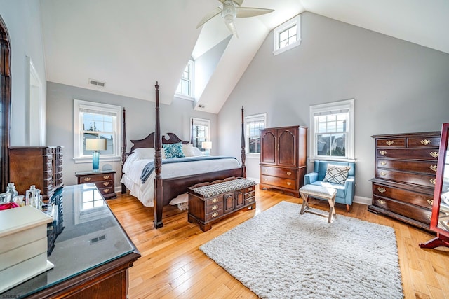 bedroom with high vaulted ceiling, multiple windows, ceiling fan, and light hardwood / wood-style floors