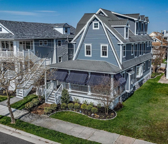 exterior space with a shingled roof, stairs, and a front yard