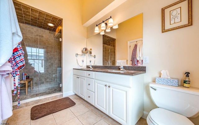 bathroom featuring vanity, tile patterned flooring, toilet, and a shower with shower door