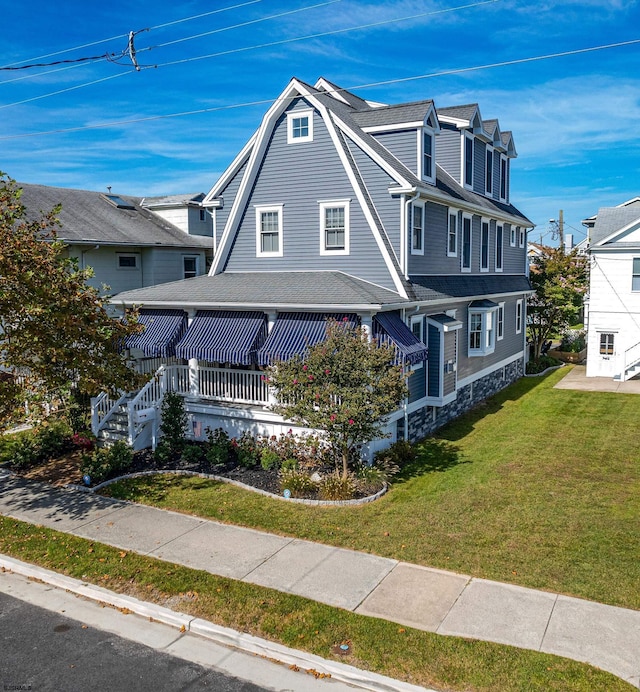 view of front of house with covered porch and a front lawn