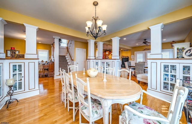 dining space with ceiling fan with notable chandelier and light hardwood / wood-style flooring