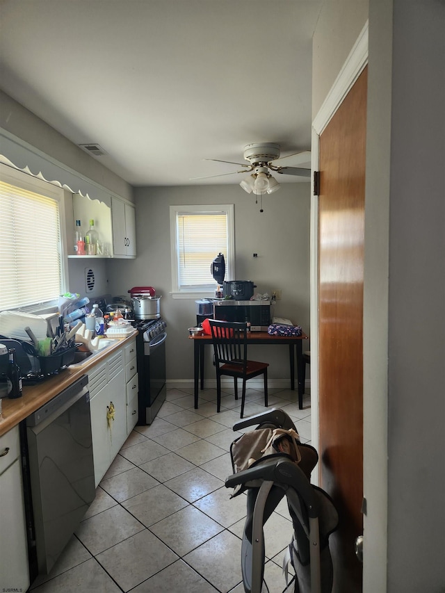 kitchen with white cabinets, black dishwasher, ceiling fan, light tile patterned floors, and gas stove