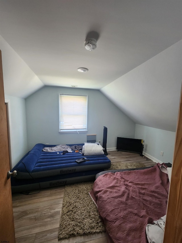 bedroom featuring lofted ceiling and hardwood / wood-style flooring