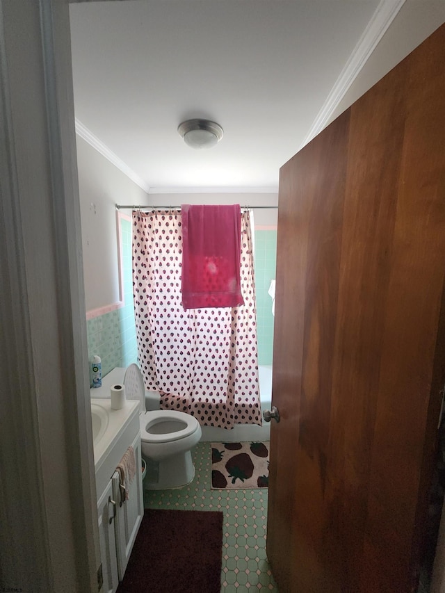 full bathroom featuring tile walls, ornamental molding, toilet, shower / bath combo with shower curtain, and vanity