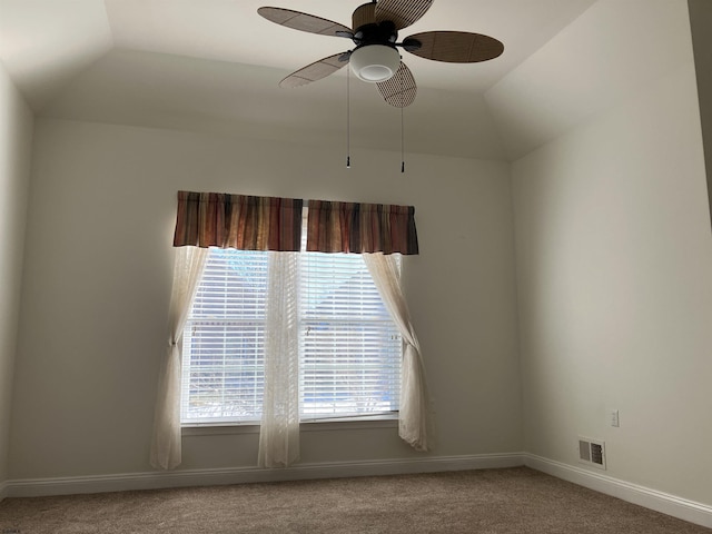 carpeted spare room featuring lofted ceiling and ceiling fan