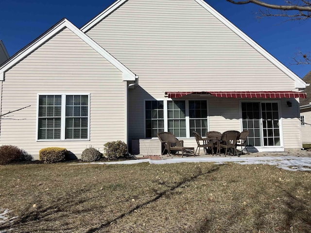 back of property featuring a patio and a lawn