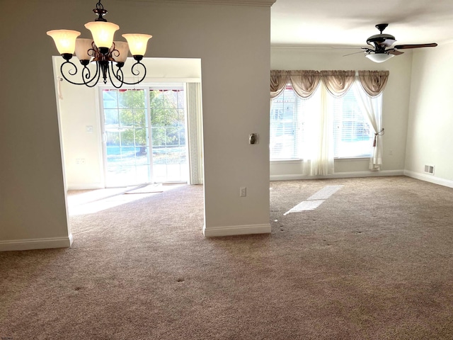 empty room with ceiling fan with notable chandelier and carpet