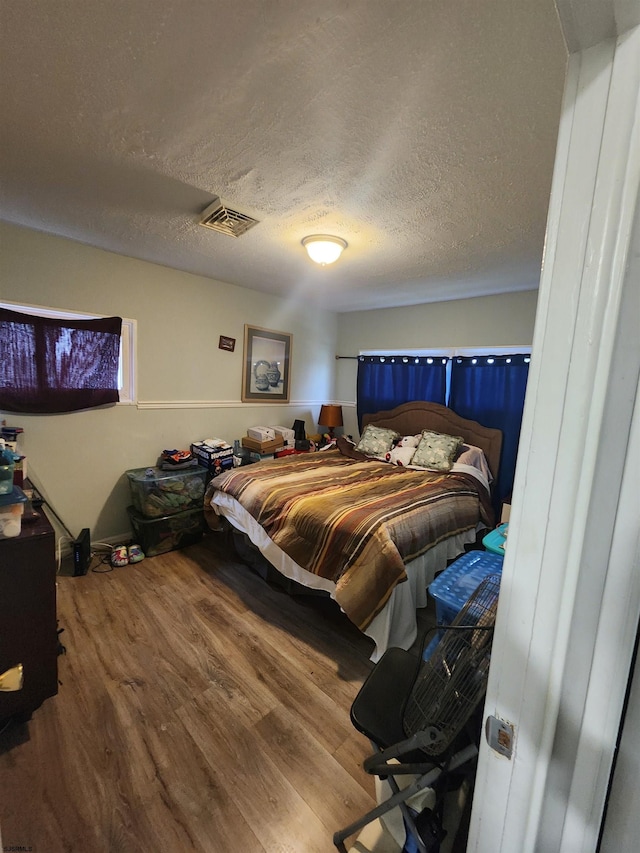 bedroom featuring a textured ceiling and hardwood / wood-style floors