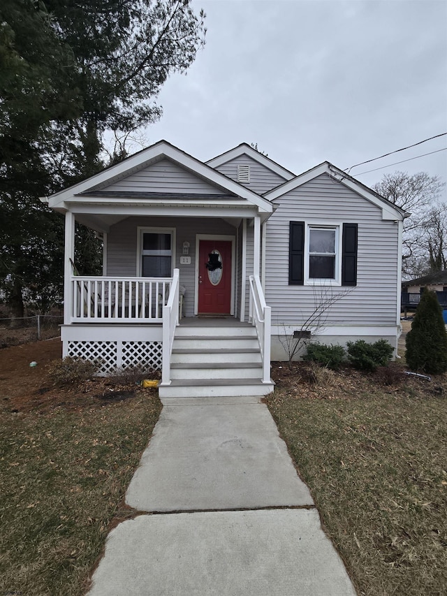 bungalow-style house with covered porch and a front lawn