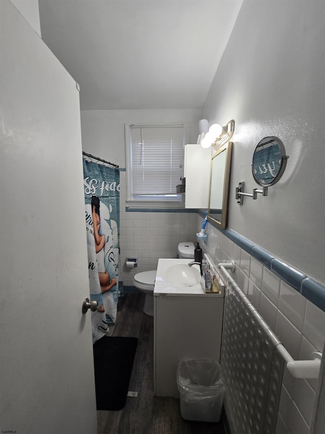bathroom with tile walls, vanity, hardwood / wood-style flooring, and toilet