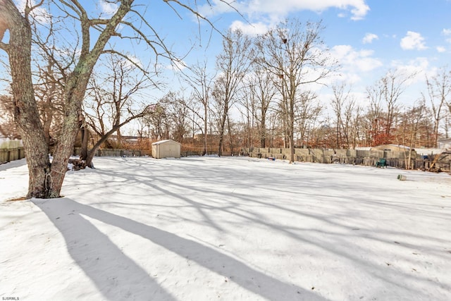 snowy yard featuring a storage shed