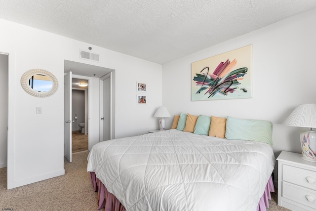 bedroom with a textured ceiling and light colored carpet