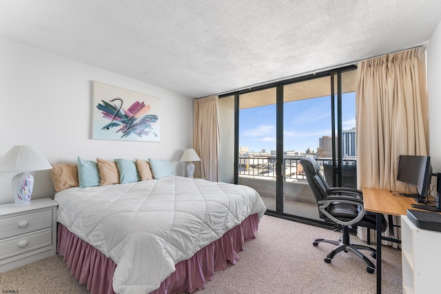 bedroom featuring a textured ceiling, a wall of windows, access to outside, and light carpet