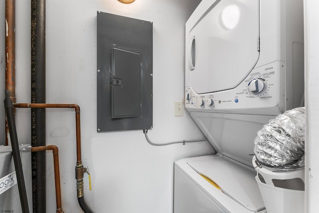 washroom featuring electric panel and stacked washer / drying machine