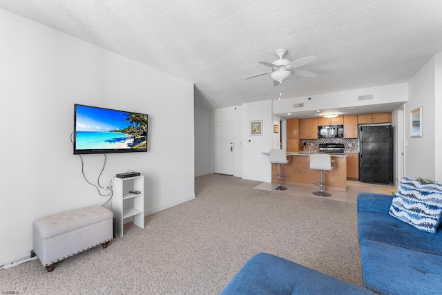 carpeted living room with a textured ceiling and ceiling fan