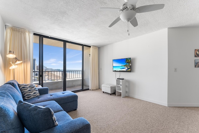 living room with a textured ceiling, ceiling fan, and carpet