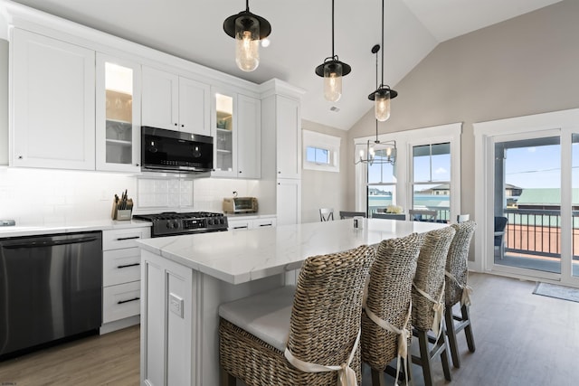 kitchen featuring a kitchen island, white cabinetry, tasteful backsplash, and dishwasher