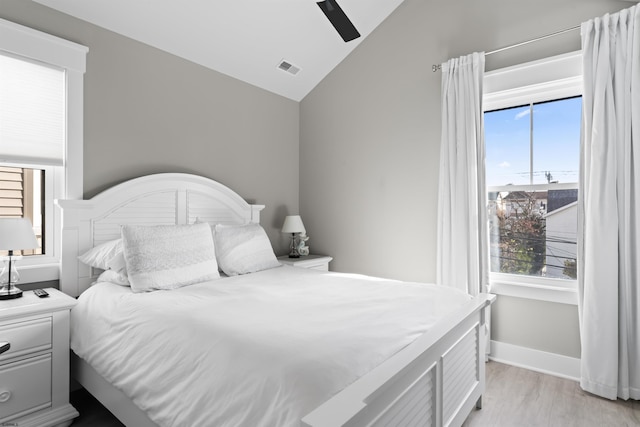 bedroom with vaulted ceiling, ceiling fan, and light hardwood / wood-style flooring