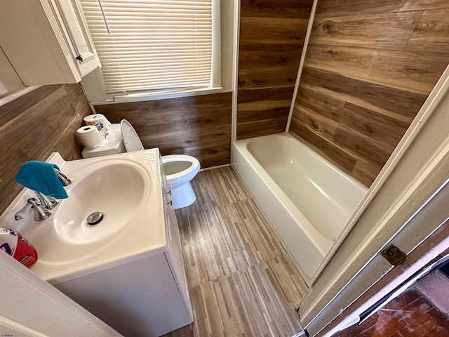 bathroom featuring toilet, wooden walls, and vanity