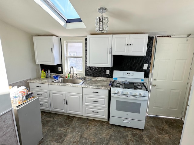 kitchen with decorative light fixtures, white cabinets, gas range gas stove, and sink