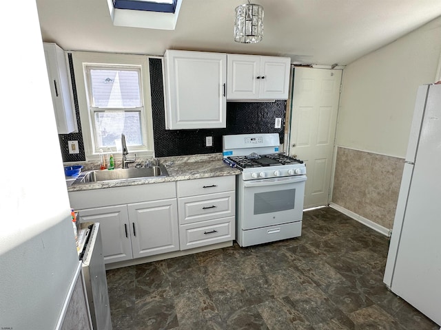 kitchen featuring white appliances, a skylight, white cabinetry, and sink