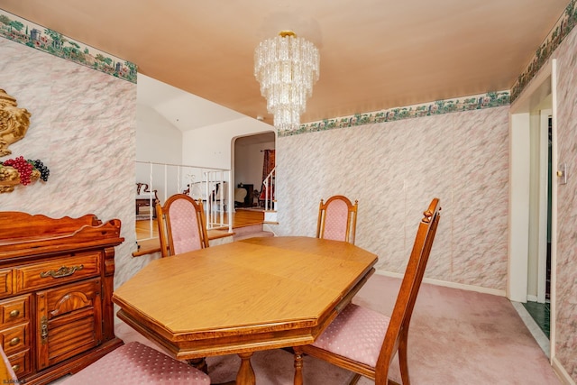 carpeted dining room with a notable chandelier