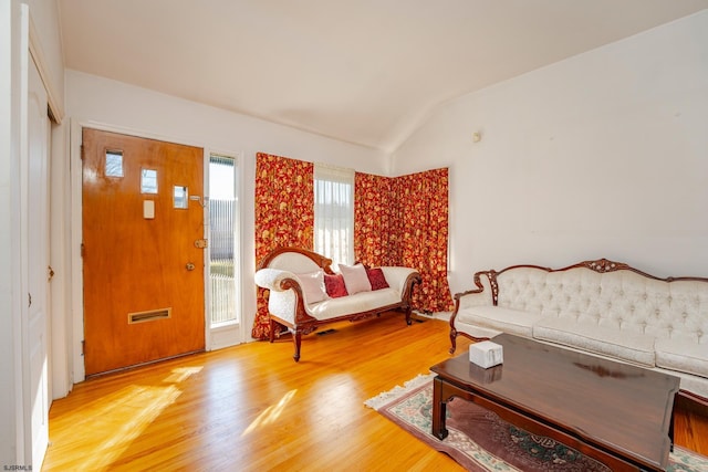 living room featuring vaulted ceiling and wood-type flooring