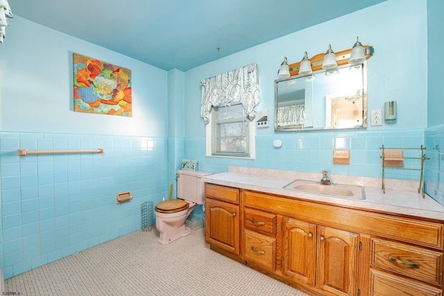 bathroom featuring tile walls, tile patterned flooring, toilet, and vanity