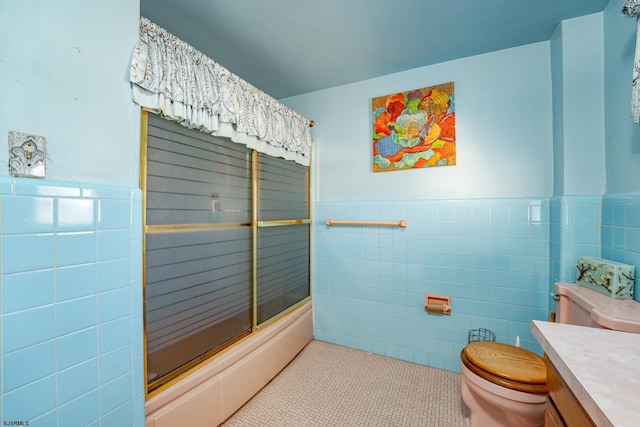 full bathroom with tile walls, vanity, shower / bath combination with glass door, and tile patterned floors