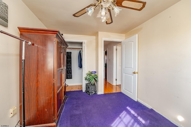 unfurnished bedroom featuring ceiling fan and dark colored carpet