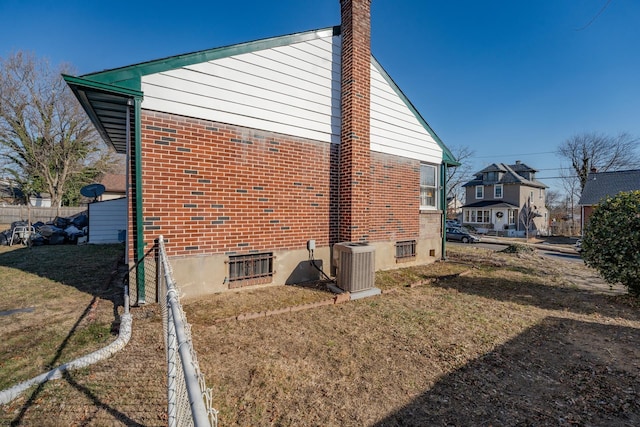 view of property exterior with central air condition unit and a yard