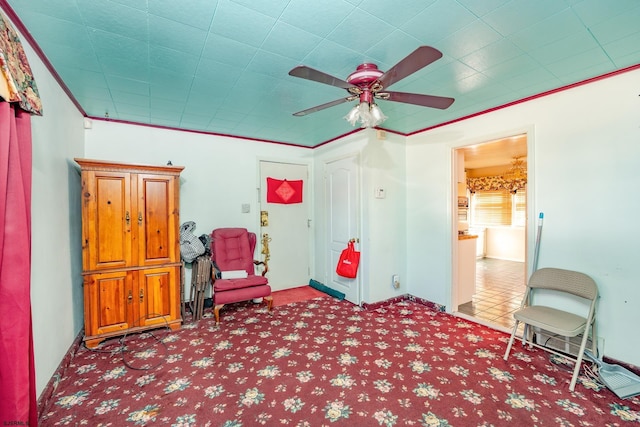 sitting room featuring ceiling fan, light colored carpet, and ornamental molding