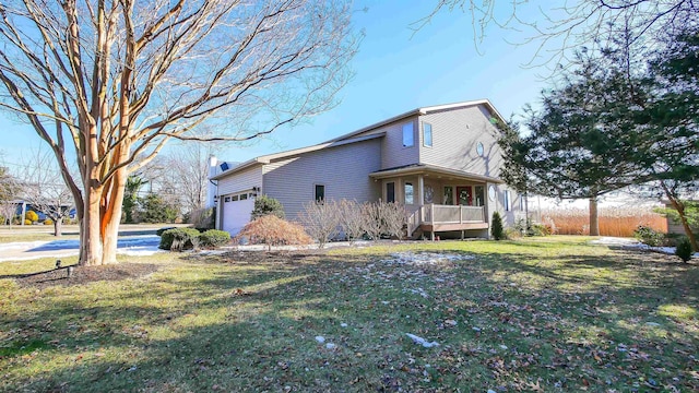 view of property exterior with a garage, a yard, and a porch