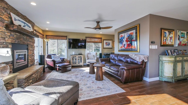 living room with ceiling fan and a fireplace