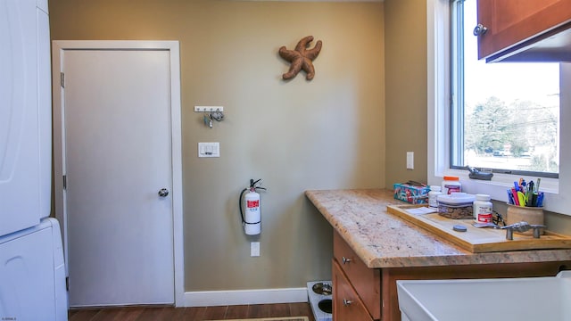 bathroom featuring stacked washing maching and dryer and hardwood / wood-style floors