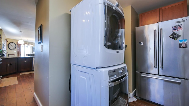 washroom featuring dark wood-type flooring and stacked washer / dryer