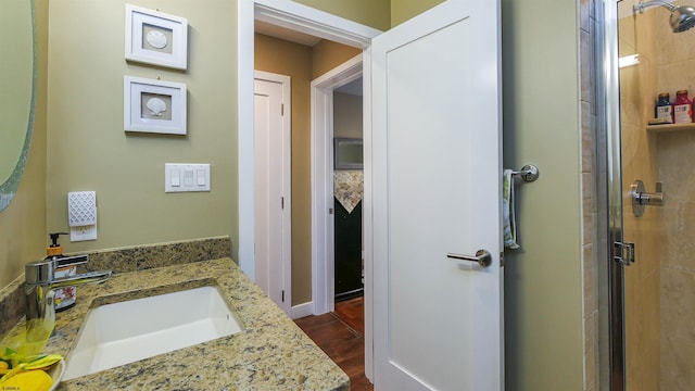 bathroom featuring wood-type flooring, an enclosed shower, and vanity