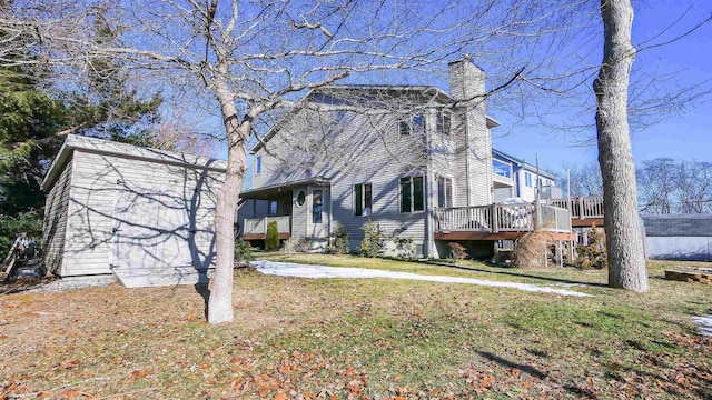 view of front of house with a front lawn, a storage unit, and a wooden deck