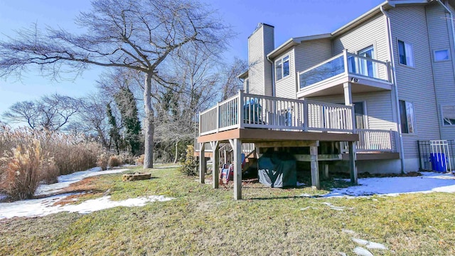 rear view of property with a deck and a lawn