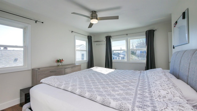 bedroom with hardwood / wood-style floors, multiple windows, and ceiling fan