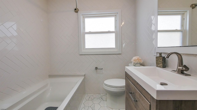 bathroom with tile patterned flooring, vanity, a washtub, and a wealth of natural light