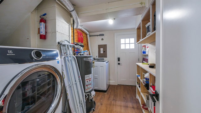 clothes washing area featuring water heater, washer / clothes dryer, electric panel, and wood-type flooring