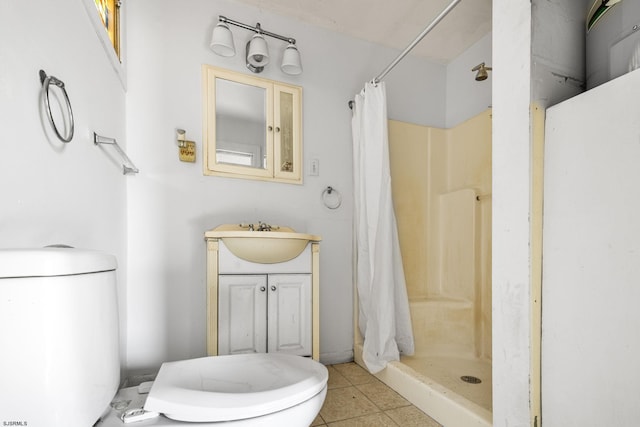 bathroom featuring toilet, tile patterned floors, walk in shower, and vanity